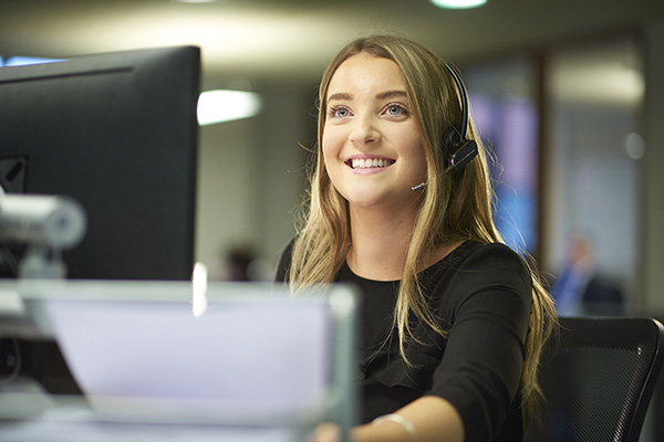 receptionist with headset and on a computer